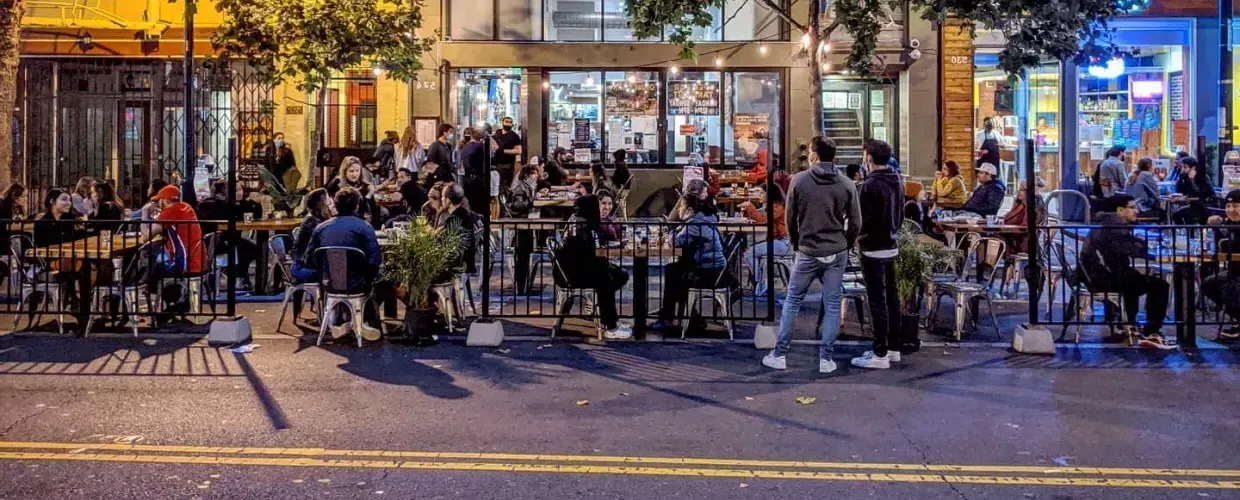 A crowd enjoys food and drink along San Francisco's Valencia Street