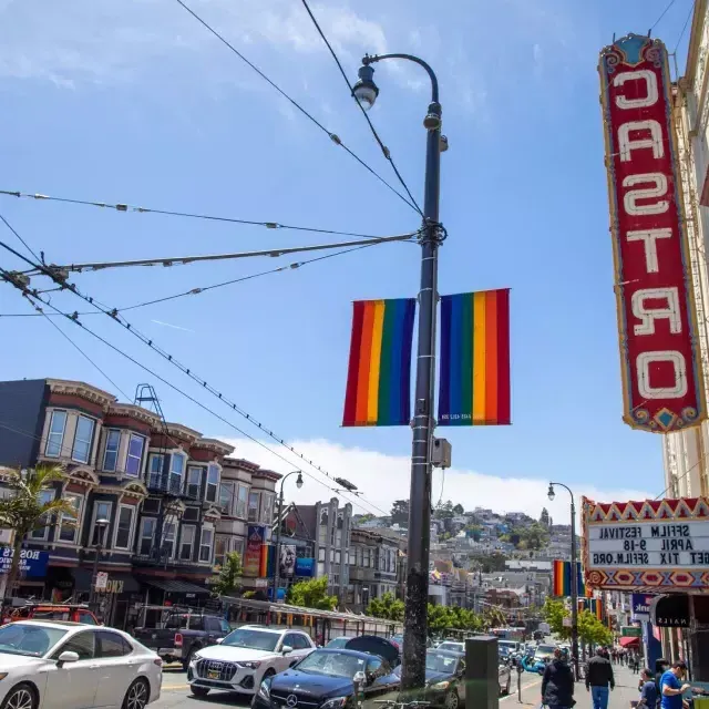 卡斯特罗区, 在贝博体彩app, 和 a placa do Teatro Castro e bandeiras arco-íris em primeiro plano.